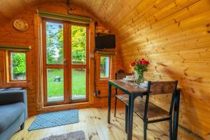 a wooden cabin with a table with flowers on it at The Chestnuts Pod with private garden. in Eccles