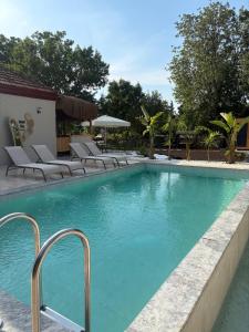 a swimming pool with lounge chairs in a resort at Hanımın Çiftliği Tents&Drinks in Fethiye +5 photos