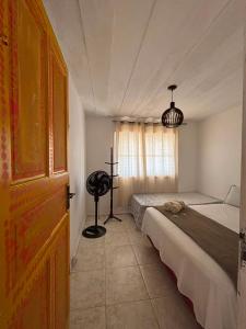 a bedroom with two beds and a fan in it at Aura House Búzios in Búzios