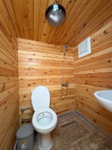 a wooden bathroom with a toilet and a sink at Hanımın Çiftliği Tents&Drinks in Fethiye