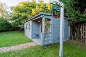 a blue shed with a sign in a yard at The Chestnuts Pod with private garden. in Eccles