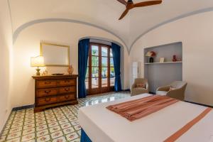 a bedroom with a bed and a dresser and a window at Villa Le Pagine Bianche in Lacco Ameno +77 photos