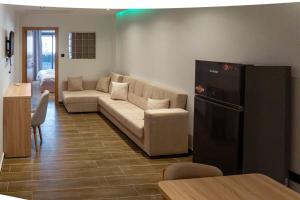 a living room with a couch and a refrigerator at Hostel Tamim in Fort de lʼEau