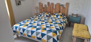 a bedroom with a bed with a wooden headboard at La maison dans les vignes in Châteauneuf-sur-Charente