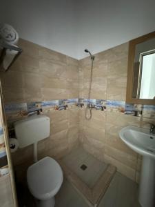 a bathroom with a toilet and a sink at KuneVain Guest House in Lezhë +109 photos