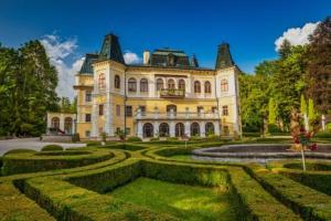 a large yellow house with a garden in front of it at Boutique Hotel Empress in Rožňava
