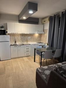 a kitchen with white cabinets and a table with chairs at Apartman Marta in Podstrana +31 photos