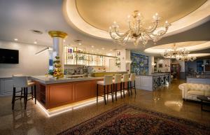 a large kitchen with a island and a chandelier at Grand Hotel Playa in Lignano Sabbiadoro