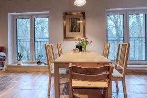 a dining room with a table and chairs and windows at Ferienwohnung Zum Bachsee in Chorin