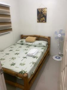 a bedroom with a bed in a room with a fan at Two Br-House with Carport in Ormoc