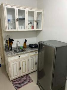 a kitchen with a stainless steel refrigerator and white cabinets at Two Br-House with Carport in Ormoc