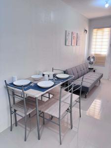 a dining room with a table and chairs and a couch at Two Br-House with Carport in Ormoc