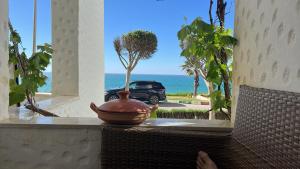 a vase sitting on a table with a view of the ocean at Marina Golf 7 in Asilah
