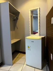 a small refrigerator in a room with a mirror at Pousada Caravela in Arraial do Cabo +17 photos