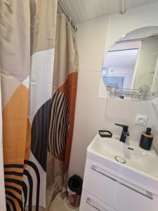 a bathroom with a shower curtain and a sink at Maison Diana in Vence