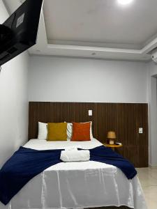 a bedroom with a large bed with a flat screen tv at Pousada Caravela in Arraial do Cabo