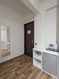 a kitchen with a white counter and a wooden door at Hotel Captain in Gonio +128 photos
