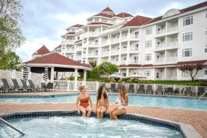 three girls sitting in the pool at a hotel at Inn at Bay Harbor in Petoskey