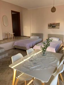 a room with two beds and a table and chairs at Villa Eleon 1 in Nea Vrasna
