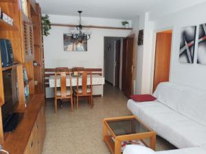 a living room with a couch and a table and chairs at Costadaurada2000 Sunset Beach Cunit in Cunit