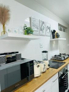 a kitchen with a counter top with a microwave at Home By The Sea in Gqeberha