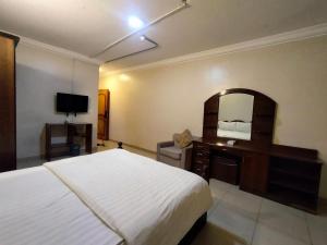 a bedroom with a bed and a dresser and a mirror at مساكن للشقق الفندقيه in Riyadh