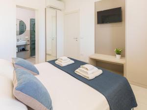 a bedroom with a bed with towels on it at Casa LE VELE in Torre Pali +28 photos