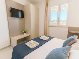 a bedroom with a bed with two towels on it at Casa LE VELE in Torre Pali