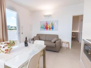 a white living room with a couch and a table at Casa LE VELE in Torre Pali