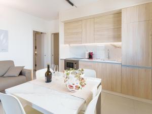 a kitchen with a white table with a bottle of wine at Casa LE VELE in Torre Pali