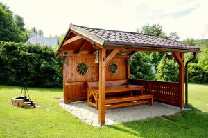 a wooden gazebo with a bench in the grass at Chata na Zbojskej - Zbojská in Pohronská Polhora +67 photos