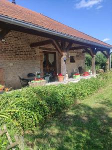 a brick house with a patio with a grill at Chez So et Compagnie in Saint-Gérand-de-Vaux