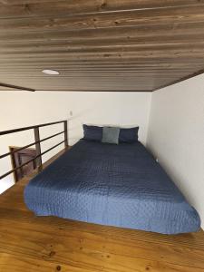 a bedroom with a blue bed with a wooden ceiling at Chitos place in Savegre