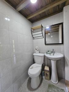 a bathroom with a toilet and a sink at Chitos place in Savegre