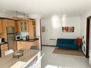 a kitchen and a living room with a blue couch at Arenales Azules in Baiona