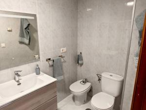a bathroom with a toilet and a sink at Arenales Azules in Baiona +20 photos