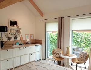 a kitchen with white cabinets and a table and chairs at The Two Branches in 't Waal