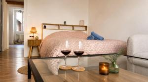 a bedroom with two glasses of wine on a table at L'Écrin Bois & Lin in Nevers
