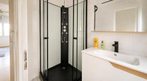 a bathroom with a shower and a sink at L'Écrin Bois & Lin in Nevers