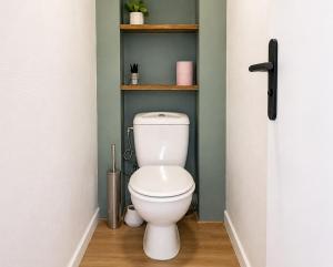 a bathroom with a white toilet in a room at L'Écrin Bois & Lin in Nevers +5 photos