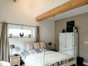 a bedroom with a white bed and a window at The Two Branches in 't Waal