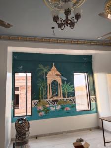 a mural on a wall in a room with windows at Happy Trails Hostel Udaipur in Udaipur
