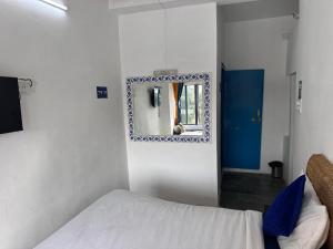 a small bedroom with a bed and a mirror at Happy Trails Hostel Udaipur in Udaipur