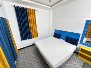 a bedroom with a bed with blue and yellow curtains at Happy Trails Hostel Udaipur in Udaipur