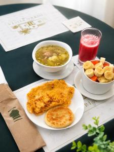 ein Tisch mit zwei Tellern Essen und einer Schüssel Suppe in der Unterkunft Hotel plata inn in Villavicencio