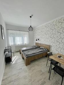a bedroom with a large bed and a table and chairs at Víkend Apartmanok in Révfülöp