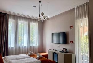 a bedroom with two beds and a flat screen tv at Annie Villa in Siófok