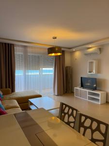 a living room with a couch and a tv at Leonard's Shengjin Apartments in Lezhë