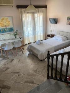 a bedroom with a bed and a table and a desk at Villa Eleon 2 in Nea Vrasna
