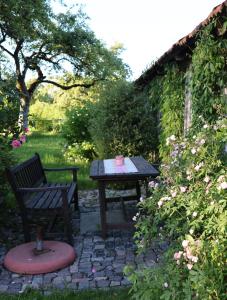 a picnic table and a bench in a garden at Ferienwohnungen Heissbauer in Wackersberg
